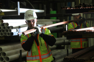 New Construction Plumbing Contractors in Uniform Carrying PVCs